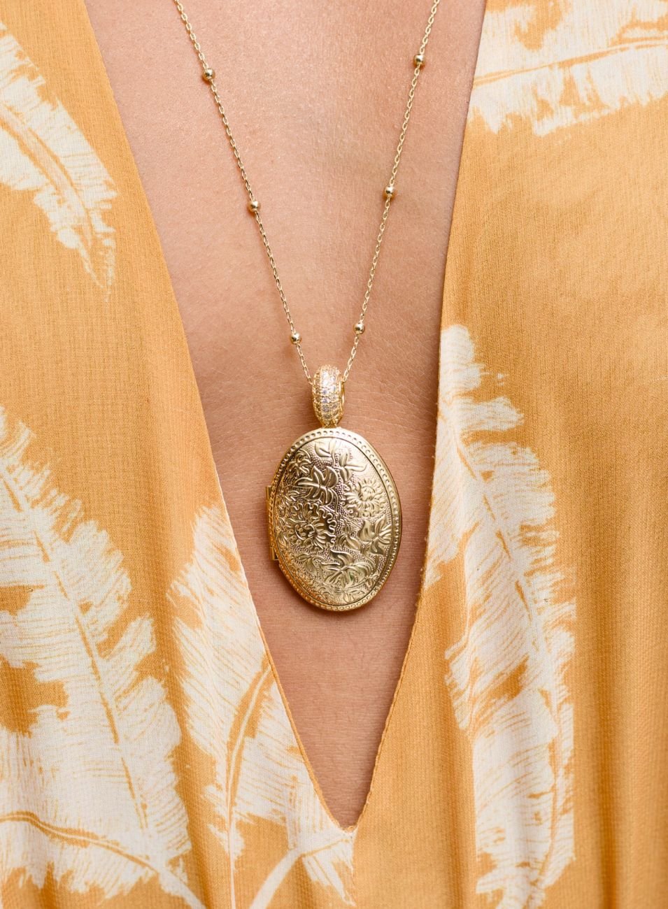 COLAR RELICÁRIO OVAL FLORES ENTREMEIO ZIRCÔNIAS BANHO OURO