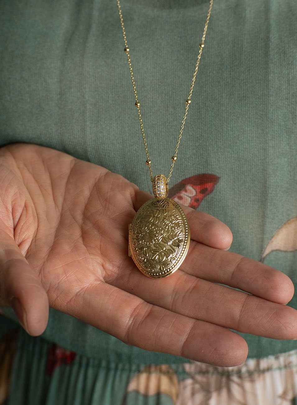 COLAR RELICÁRIO OVAL FLORES ENTREMEIO ZIRCÔNIAS BANHO OURO