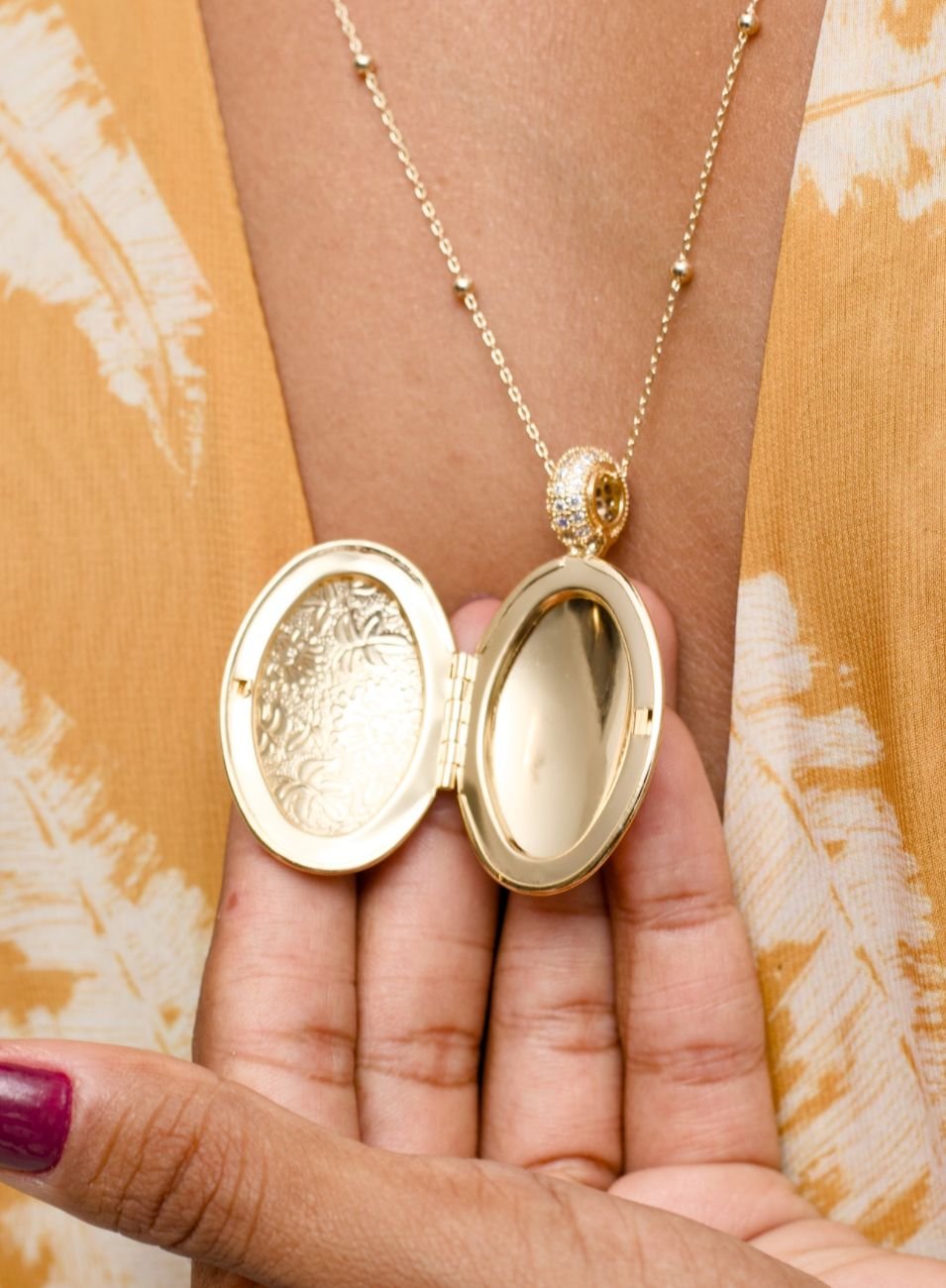 COLAR RELICÁRIO OVAL FLORES ENTREMEIO ZIRCÔNIAS BANHO OURO