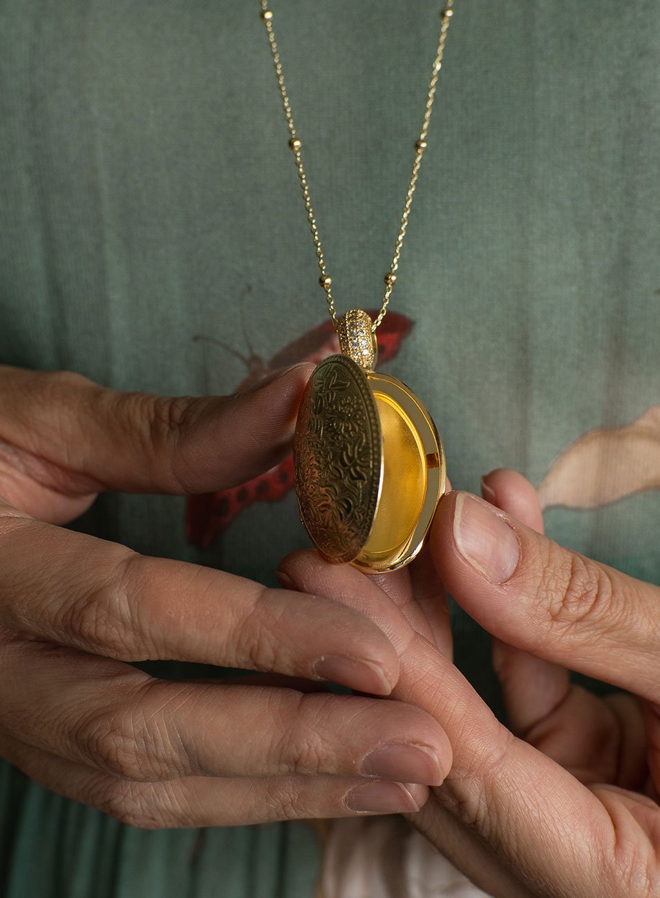 COLAR RELICÁRIO OVAL FLORES ENTREMEIO ZIRCÔNIAS BANHO OURO