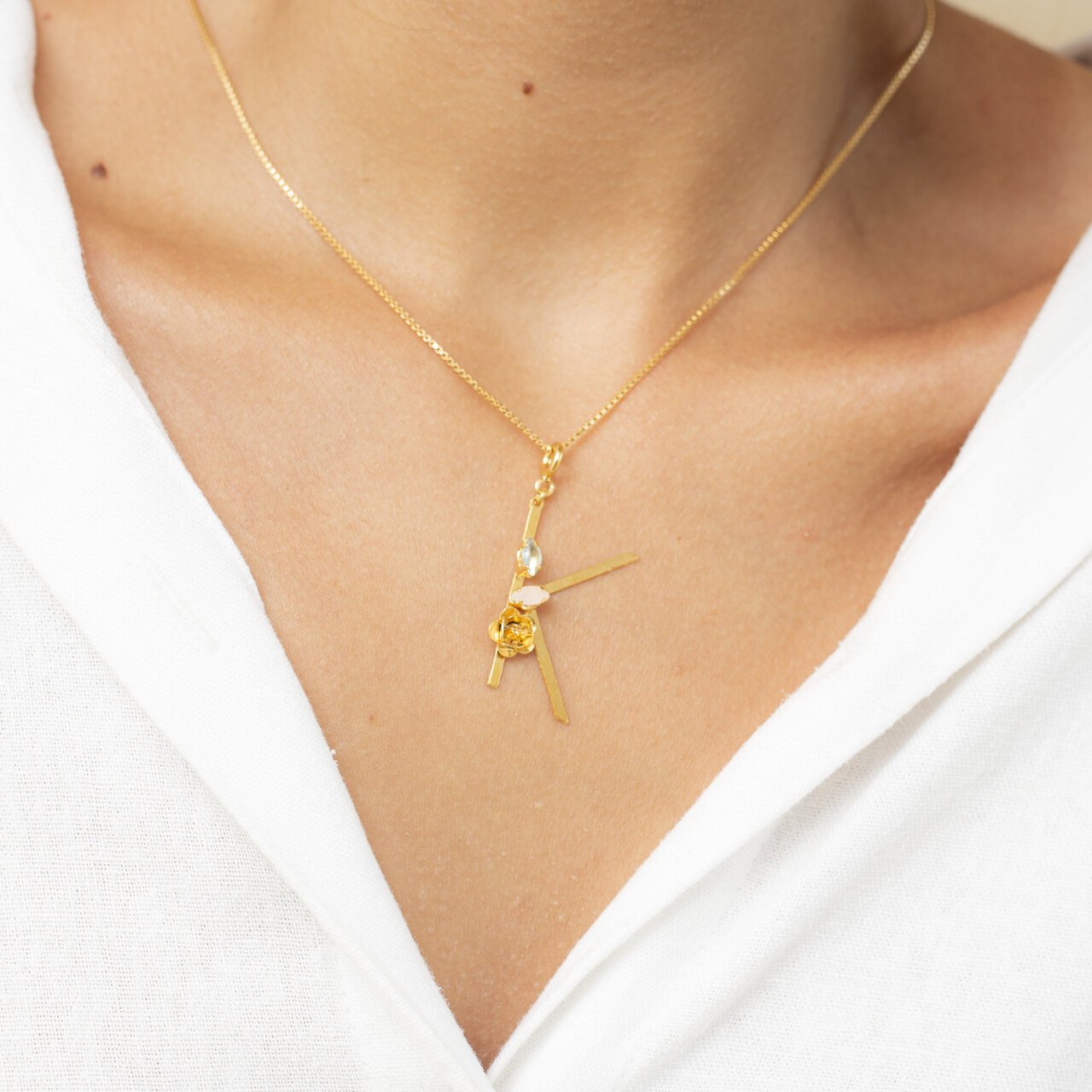 PINGENTE LETRA K CRAVAÇÃO FLOR NAVETE LILÁS/ROSA BANHO OURO